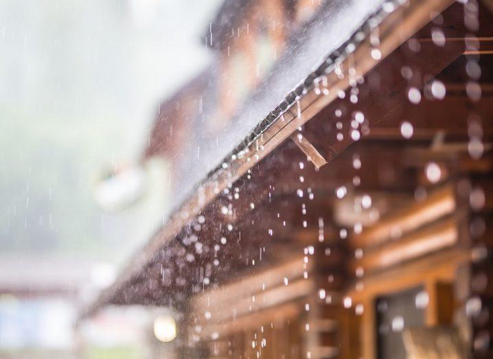 rain droplets pouring down from brown wooden roof.