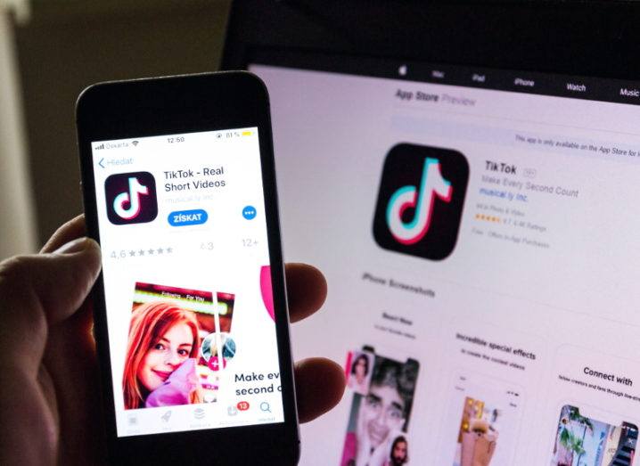 View of TikTok app icon on iPhone open in app store and on app store in front of a computer screen.