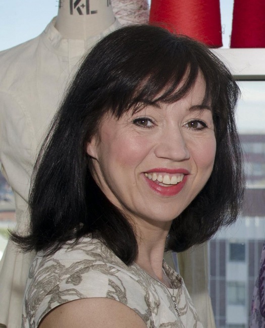 close-up of woman with mid-length black hair and red lipstick.