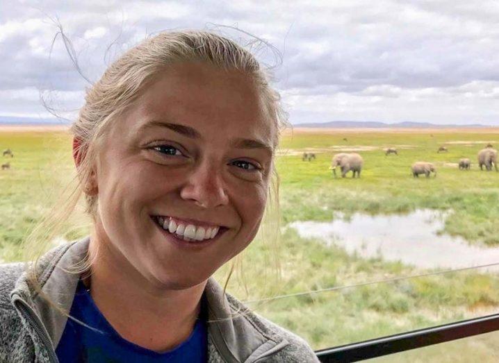 Headshot of Lindsay Mosher smiling against a backdrop of elephants in the wild.