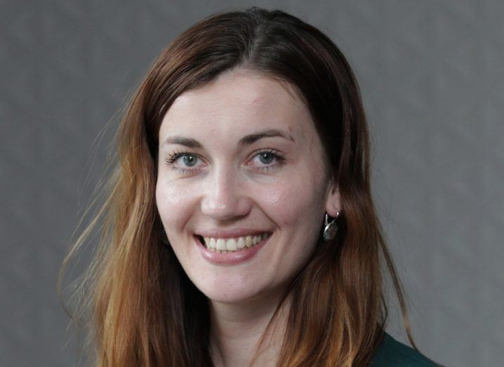 Headshot of Luiza Wasiewska, a smiling long-haired woman in a green cardigan.