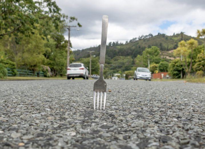 A picture of a silver fork embedded on the road.