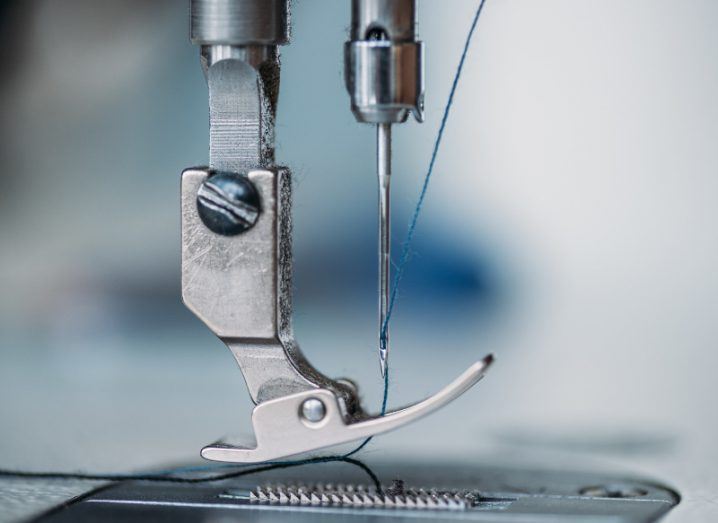 close-up shot of needle and thread of silver sewing machine.