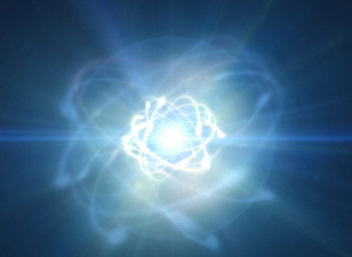 3D render of glowing atom coloured blue, surrounded by moving particles.