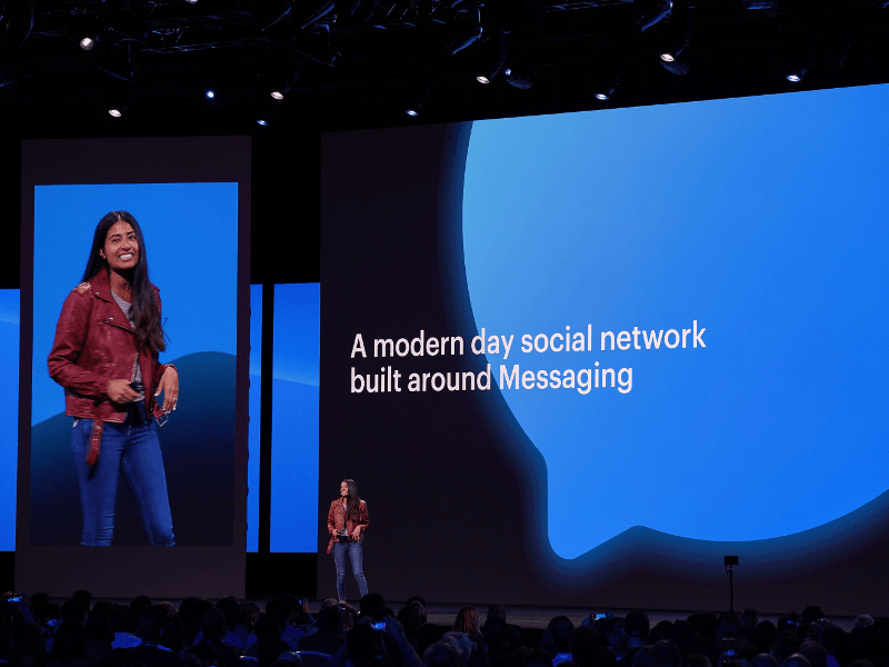 Woman in red leather jacket on stage at Facebook F8 conference.