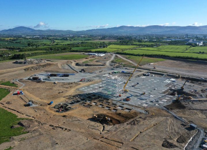 A construction site for a new pharmaceutical plant in Louth, Ireland, under a blue sky with mountains on the horizon.