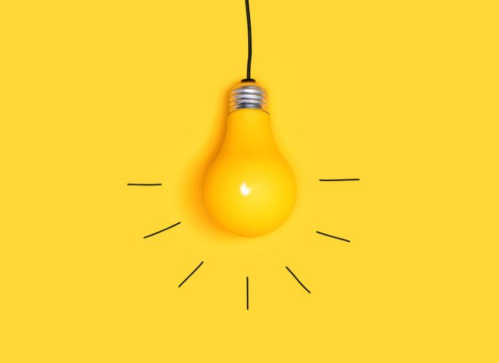 A yellow lightbulb on a matching yellow background is marked out with streaks of light emanating from the bulb.