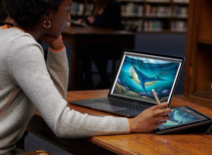 Woman combining her iPad with her MacBook using the new macOS Catalina sidecar feature.