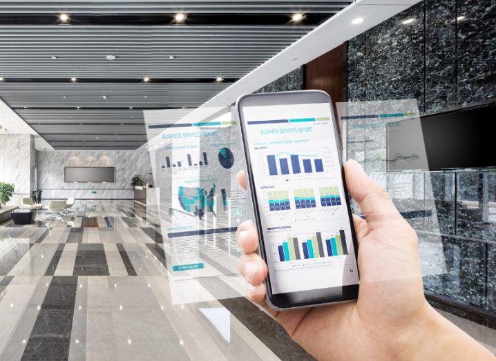 Smartphone holding key business data in a hall of a building.