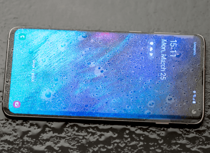 A Samsung Galaxy S10 covered in drops of water.