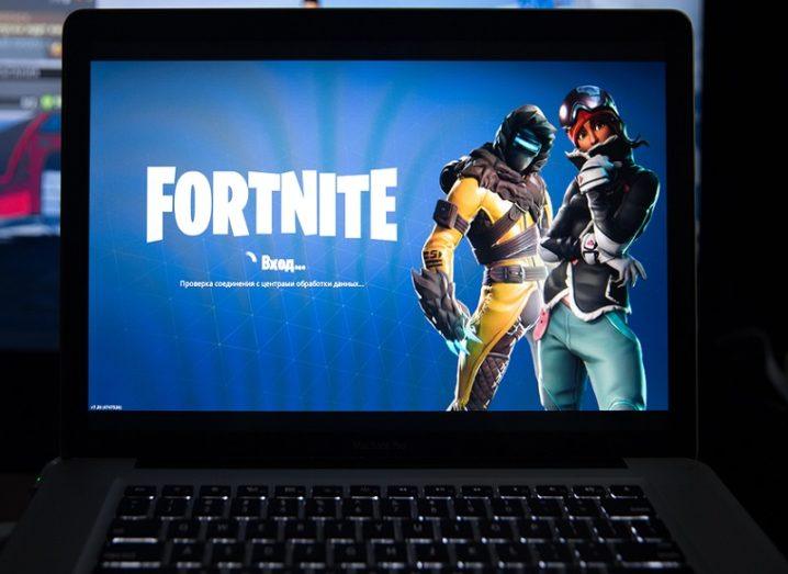 Close-up of a laptop with the Fortnite loading page on screen.
