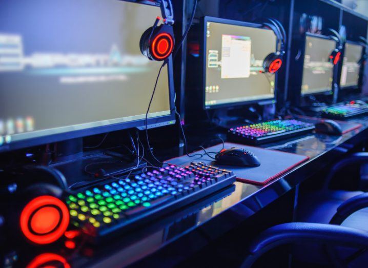 View of rainbow underlights for gaming studio filled with computers with bright headphones.