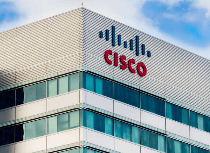 Cisco's facility in San Francisco: a tall grey building with green windows and the Cisco logo on the front, with a blue sky in the background.