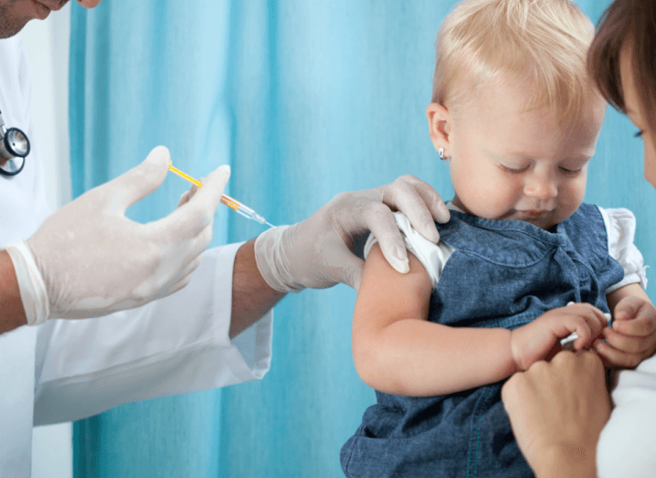 A young child receiving a vaccine from a doctor.