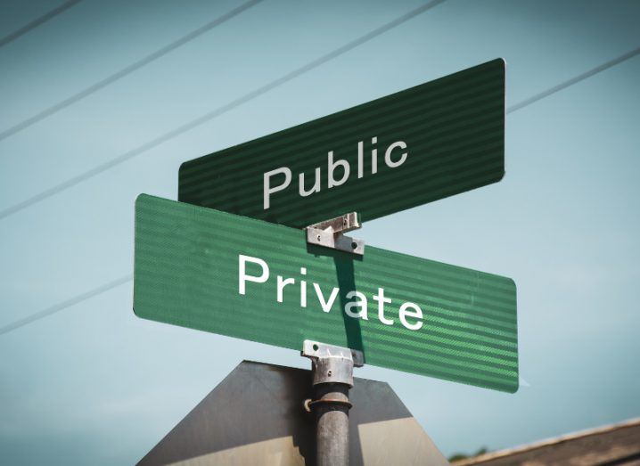 Green street signs for perpendicular streets; one is labelled ‘Public’ and the other ‘Private’.