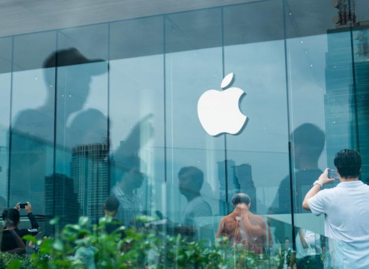 View of apple logo on front of glass building.