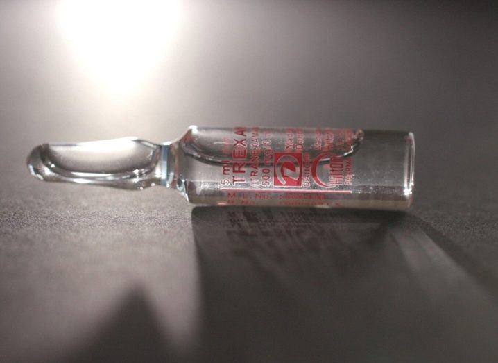 Close-up of a glass vial of the TXA drug on a table.