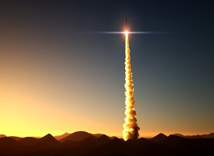 3D render of a rocket taking off into space at dusk.