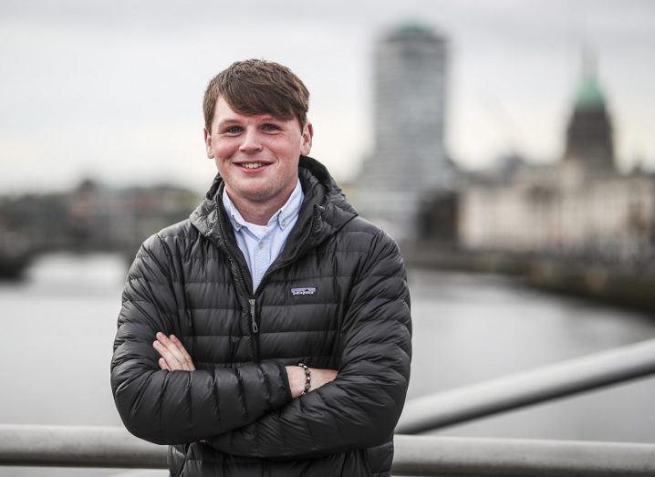 Shane Curran in a black jacket smiling overlooking the Liffey river.