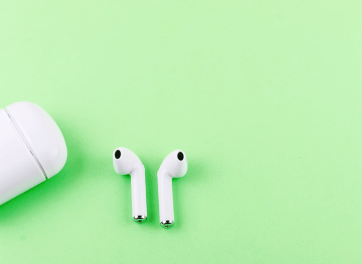 AirPods and a charging case on a lime green background.