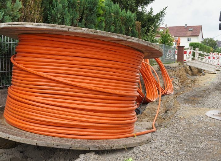 An orange roll of cable on a spool in a housing estate.
