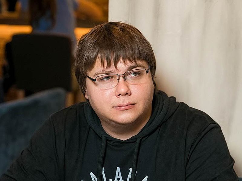 View of man with glasses and brown hair in black hoodie looking off to the side of the camera.