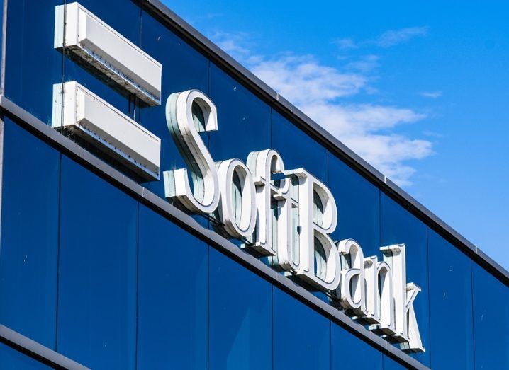 SoftBank logo on the side of a glass building against a blue sky.