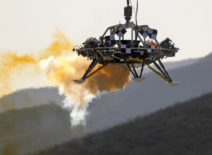China Mars lander hovering in mid-air emitting rust-coloured smoke.