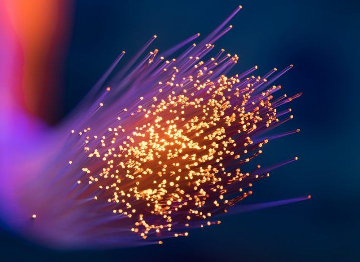 Fibre optic cable glowing orange and purple against a black background.