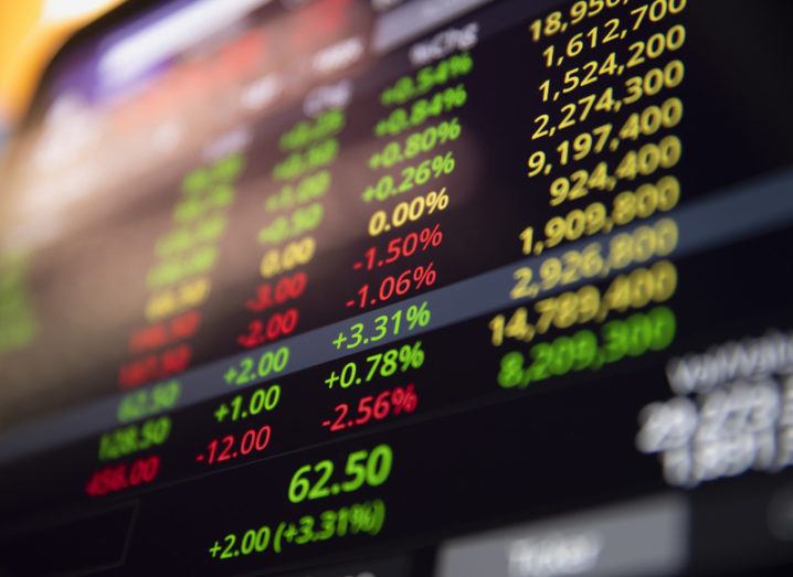 View of stock market screen lit up with figures and stock prices and percentages.