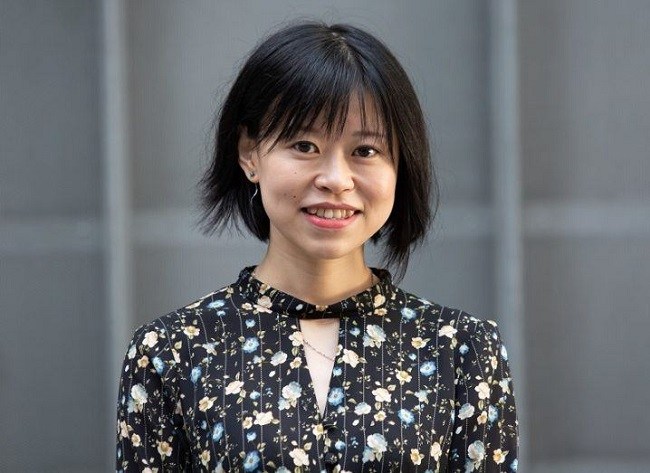 Dr Wenyue Zou smiling while wearing a shirt with multi-coloured flowers.