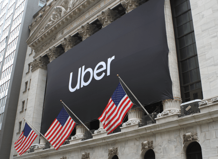 A black banner on the New York Stock Exchange building that says Uber.