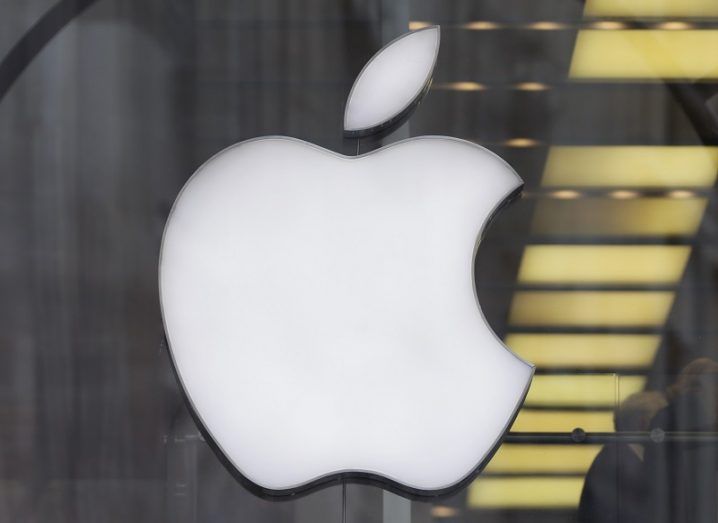 Large white Apple logo on a glass wall.