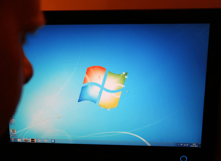 A person looking at a computer screen that is displaying Windows 7.