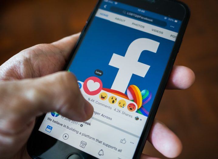 Facebook app open on a smartphone held by a hand.