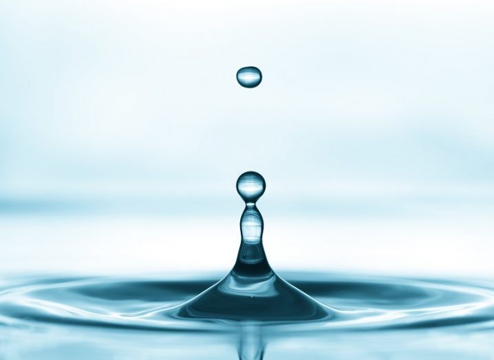 A water drop hitting a water surface, creating a ripple effect.