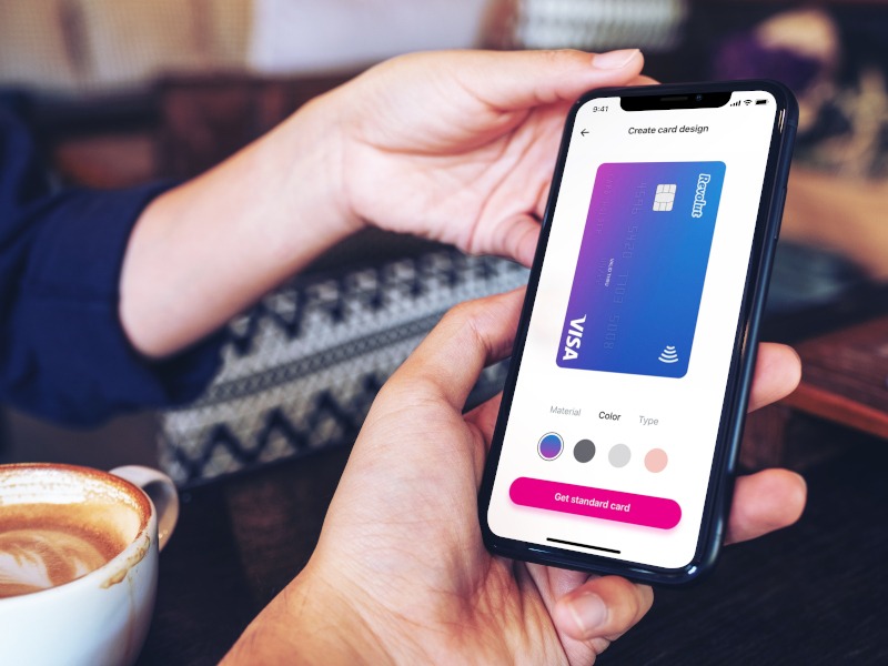 Image of Revolut app open on a phone in a person’s hand in a cafe setting.