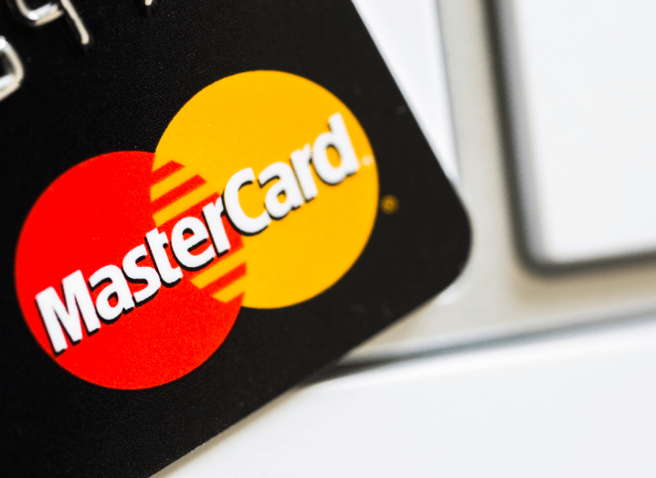 A black plastic card with the Mastercard logo printed on the front of it.