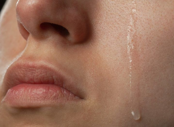 A woman's face with a teardrop falling down her cheek.
