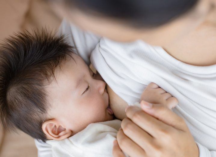 Image of a mother breastfeeding a small, dark-haired baby.