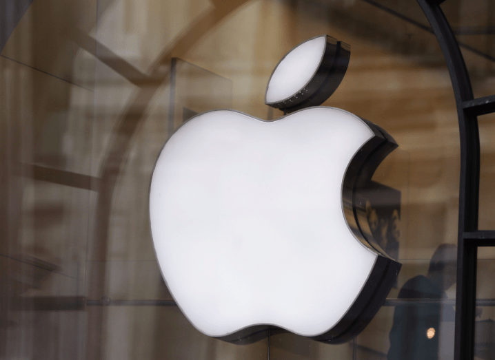 The Apple logo displayed on the front of a glass storefront.