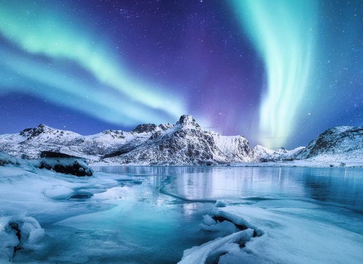 Aurora borealis over an Arctic landscape.