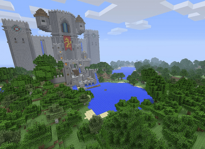 A large castle built out of blocks on Minecraft, set in a forest with a body of water surrounded by trees made from blocks.