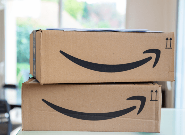 Two brown cardboard Amazon boxes stacked up in a bright room.