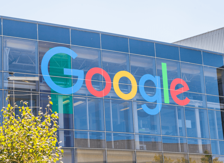 The Google logo on the front of a glass office building.