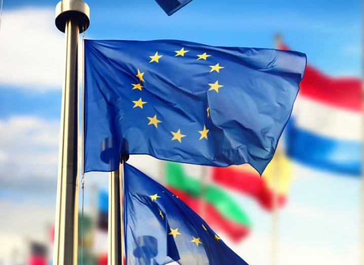 EU flags waving in front of European Parliament building.