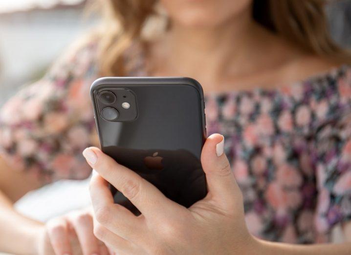 Woman holding an iPhone 11.