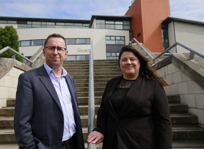 Donal O'Shea and Mairin Rafferty standing on a set of steps up to a large building.