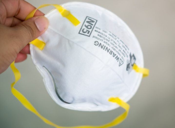 Close-up of an N95 mask with yellow straps.