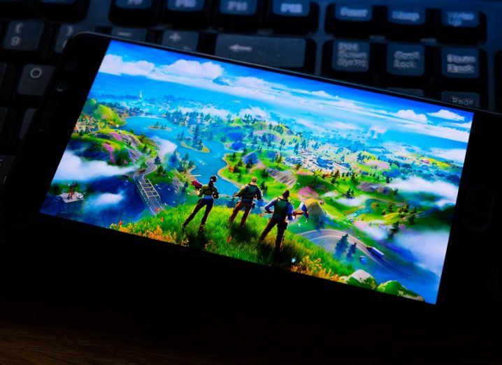 Fortnite on an Android phone in a dark room beside a keyboard.